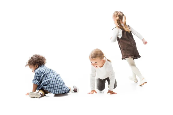 Divertidos niños multiculturales jugando juntos, aislados en blanco - foto de stock