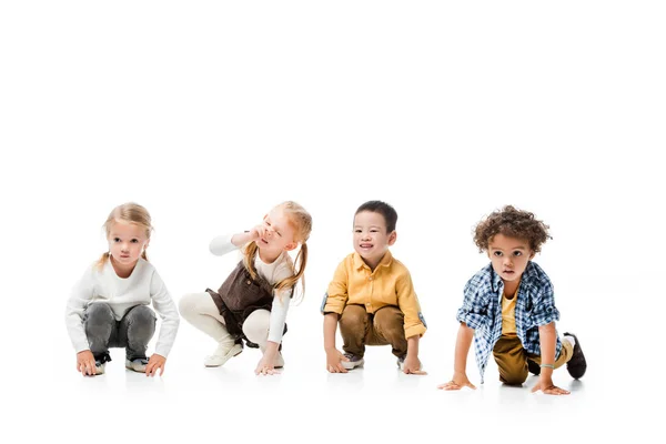 Эмоциональные мультикультурные дети играют изолированно на белом — стоковое фото