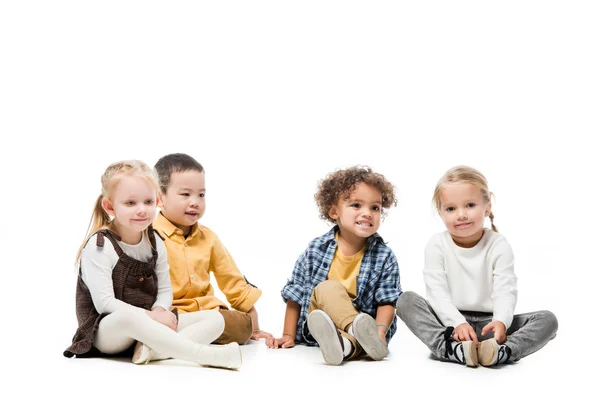 Bonito multicultural crianças sentado juntos no branco — Fotografia de Stock