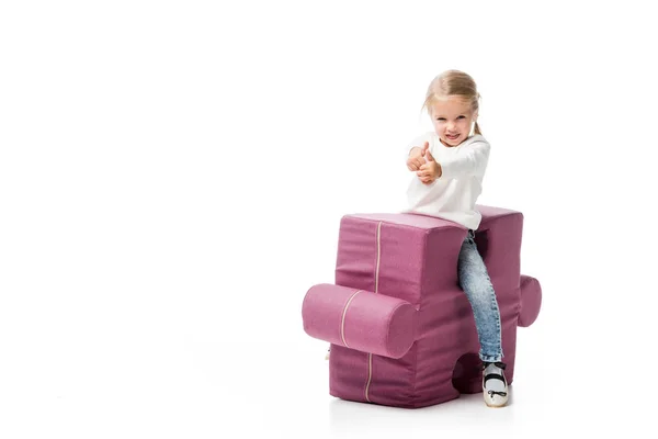Glückliches Kind zeigt Daumen nach oben auf lila Puzzle-Stuhl, isoliert auf weiß — Stockfoto