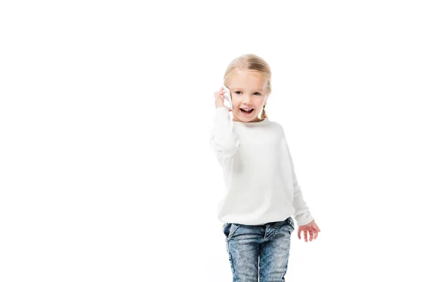 Niño adorable emocionado hablando en el teléfono inteligente, aislado en blanco - foto de stock