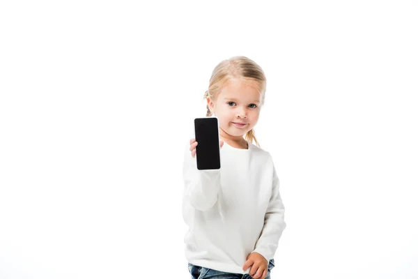 Очаровательный ребенок показывает смартфон с чистым экраном, изолированный на белом — стоковое фото