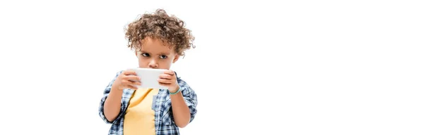 Plano panorámico de niño afroamericano pequeño usando el teléfono inteligente, aislado en blanco - foto de stock