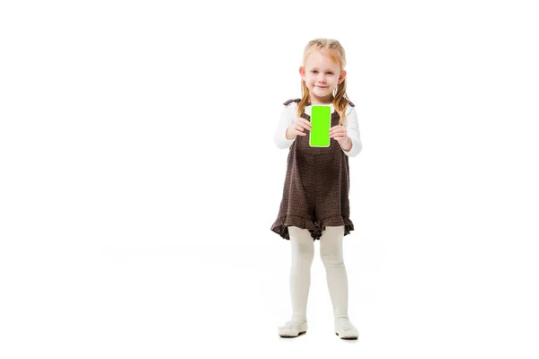 Чарівна дитина, що показує смартфон із зеленим екраном, ізольована на білому — стокове фото