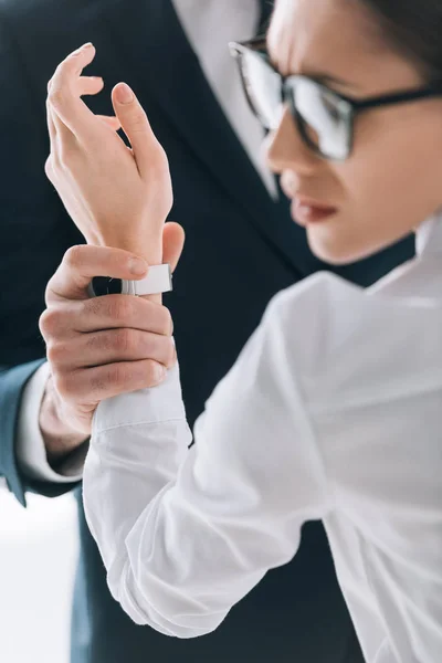 Cropped view of businessman holding hand of scared secretary in office — Stock Photo