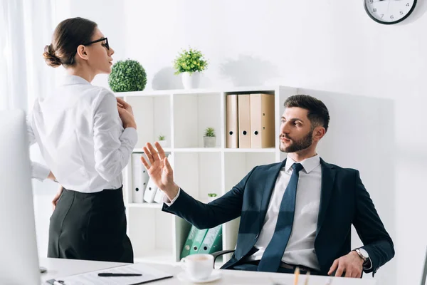 Bell'uomo d'affari in giacca e cravatta guardando e toccando segretario in carica — Foto stock