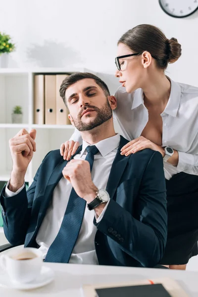 Sexy secretaria con grande pecho haciendo masaje a hombre de negocios en oficina - foto de stock
