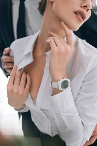 Обрізаний вид бізнесмена торкається секретаря з великою грудьми в офісі — стокове фото