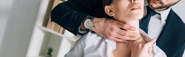 Panoramic shot of businessman in suit hugging secretary in office — Stock Photo