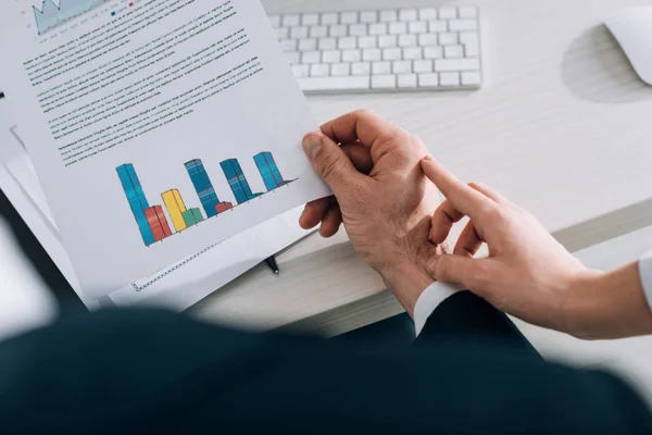 Abgeschnittene Ansicht der Sekretärin, die die Hand des Geschäftsmannes im Büro berührt — Stockfoto