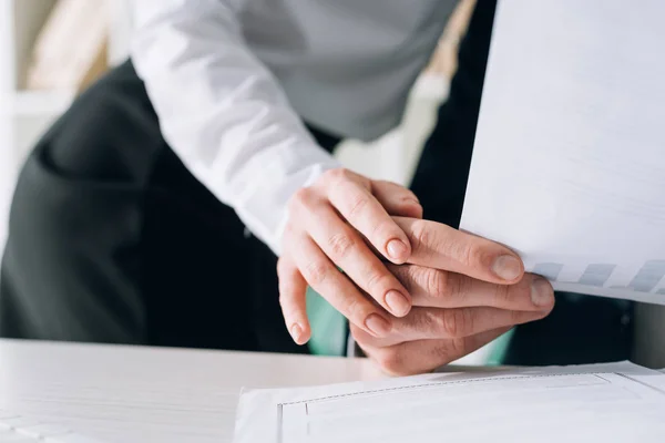 Abgeschnittene Ansicht der Sekretärin, die die Hand des Geschäftsmannes im Büro berührt — Stockfoto