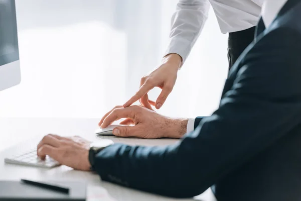 Cropped view of secretary touching hand of businessman in office — Stock Photo