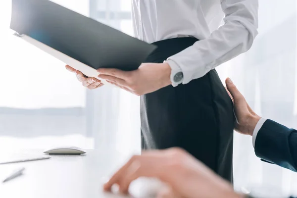 Cropped view of businessman touching butt of secretary in office — Stock Photo