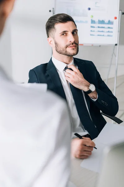 Selective focus of handsome businessman in suit looking at secretary in office — Stock Photo