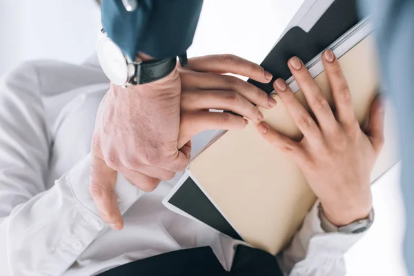 Cropped view of businessman touching hand of secretary in office — Stock Photo