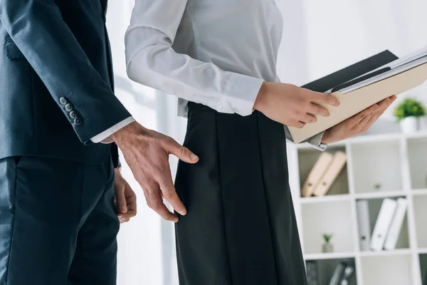 Cropped view of businessman touching butt of secretary in office — Stock Photo