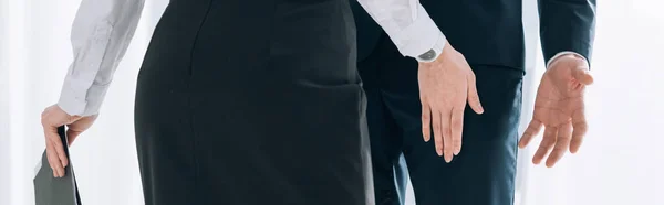 Panoramic shot of secretary touching leg of businessman in office — Stock Photo