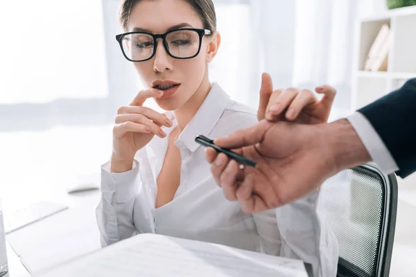 Visão cortada de empresário dando caneta a mulher de negócios com grande peito no escritório — Fotografia de Stock