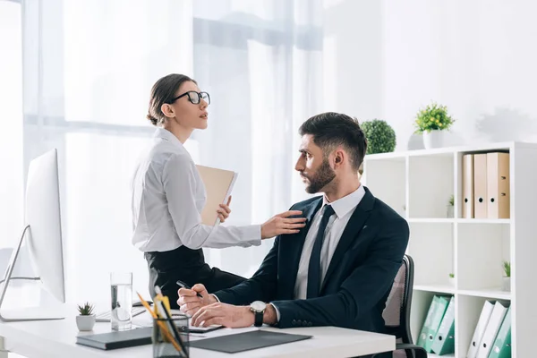 Attraktive Sekretärin sitzt am Tisch und verführt Geschäftsmann im Büro — Stockfoto