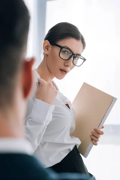 Selective focus of attractive secretary with big breast seducing businessman in office — Stock Photo