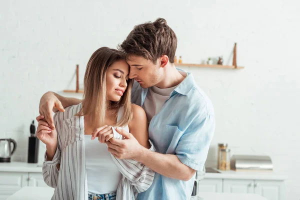 Homem bonito de mãos dadas com namorada atraente em casa — Fotografia de Stock