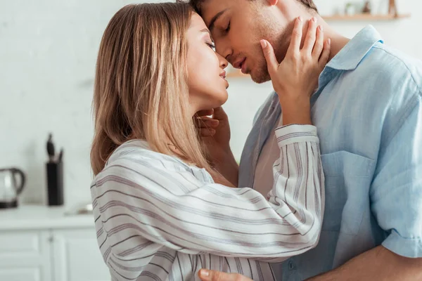 Atractiva mujer con los ojos cerrados tocando novio - foto de stock