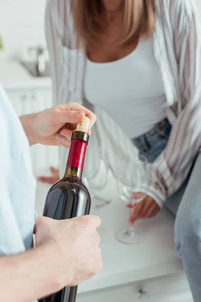 Ausgeschnittene Ansicht von Mann mit Flasche Wein in der Nähe von Mädchen zu Hause — Stockfoto