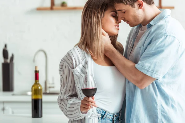 Vista laterale di bell'uomo che tocca ragazza con grande seno che tiene bicchiere di vino — Foto stock