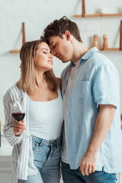 Schöner Mann steht mit sexy Mädchen mit einem Glas Wein — Stockfoto