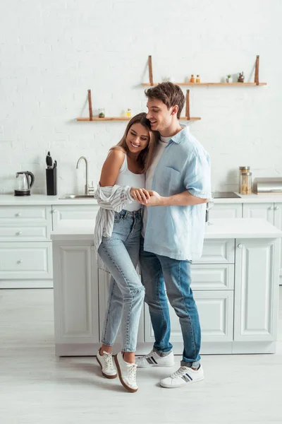 Щаслива пара посміхається, тримаючи руки вдома — Stock Photo