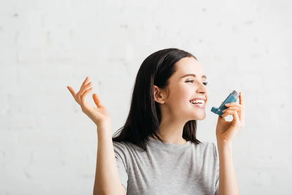 Belle fille souriant tout en tenant inhalateur à la maison — Photo de stock