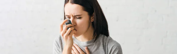 Inyección panorámica de mujer enferma usando inhalador asmático en casa - foto de stock