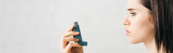 Side view of young woman holding inhaler on white background, panoramic shot — Stock Photo