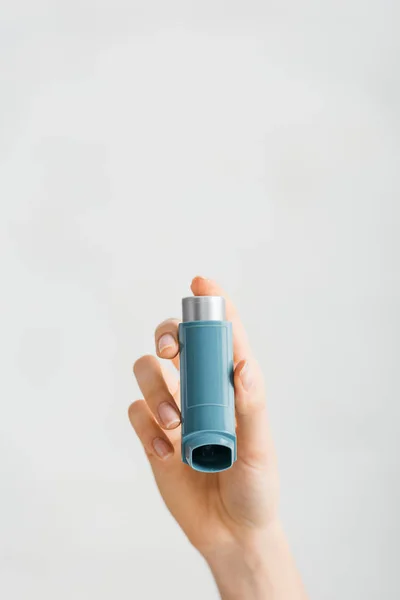 Vista recortada de niña sosteniendo inhalador aislado en blanco - foto de stock