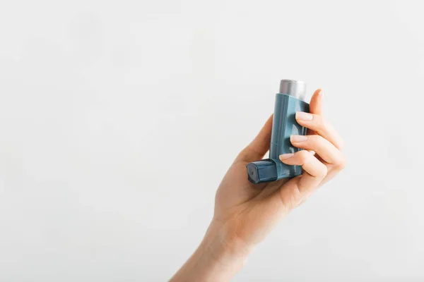 Vista recortada del inhalador en mano femenina aislada en blanco - foto de stock