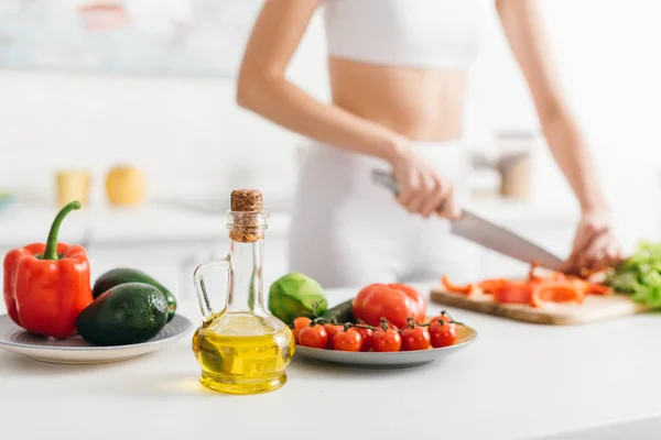 Focus selettivo di verdure biologiche e avocado vicino all'insalata di cucina sportiva sul tavolo della cucina — Foto stock