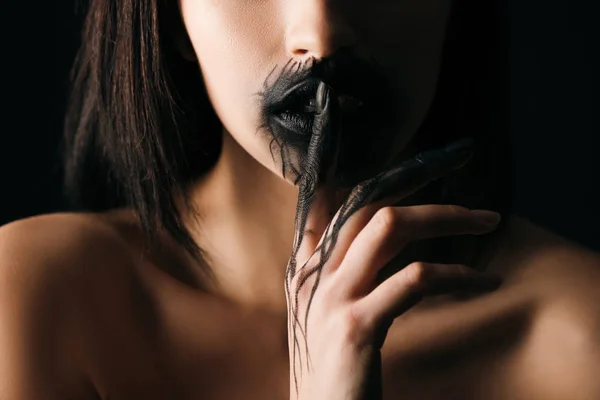 Vista recortada de mujer desnuda con labios pintados de negro y mano mostrando gesto de silencio aislado en negro - foto de stock