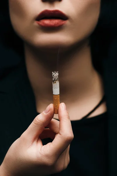Enfoque selectivo de la mujer joven sosteniendo cigarrillo - foto de stock