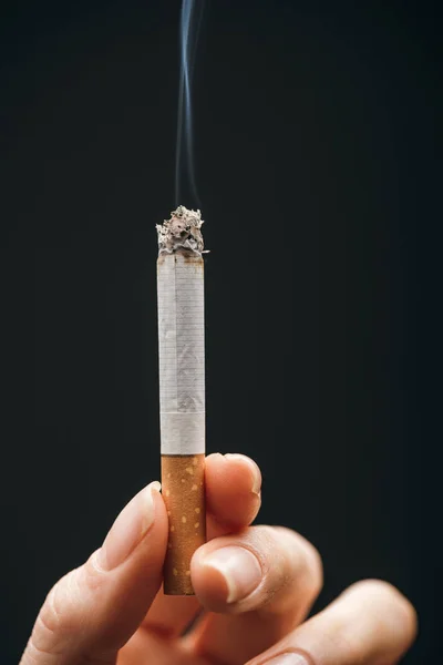 Close up view of woman holding cigarette isolated on black — Stock Photo