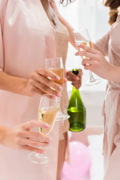 Vista cortada de meninas com copos e garrafa de champanhe na despedida de solteira — Fotografia de Stock