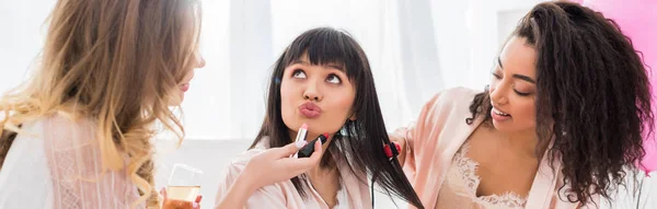 Panoramic shot of multicultural girls making hair styling and makeup with lipsticks on bachelorette party — Stock Photo