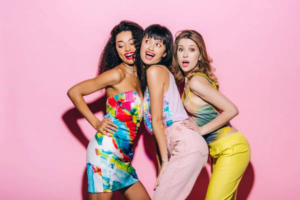 Sorrindo namoradas multiétnicas na moda posando em rosa — Fotografia de Stock