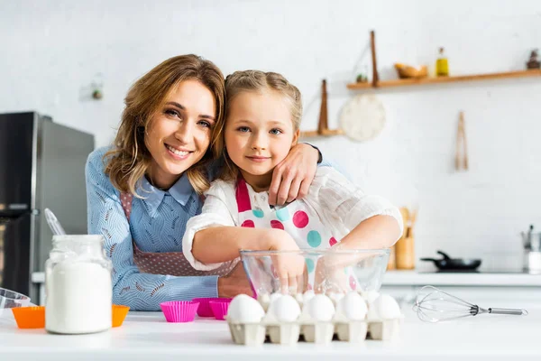 Enfoque selectivo de madre e hija preparando masa para magdalenas en la cocina - foto de stock