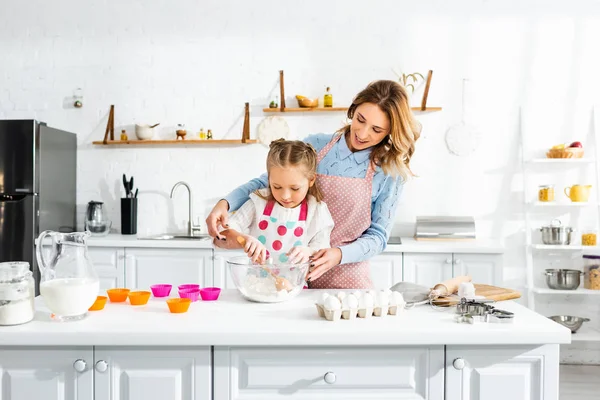 Schöne attraktive Mutter steht hinter süßer Tochter beim Kneten von Teig — Stockfoto