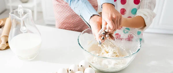 Cropped view of mother and daughter kneading dough together in bowl — Stock Photo