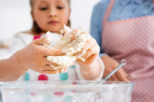 Selective focus of child hands in dough above bowl — Stock Photo