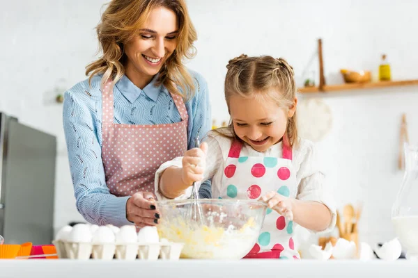 Bela mãe atraente e filha bonita bolinhos de cozinha felizes e positivos juntos em casa — Fotografia de Stock