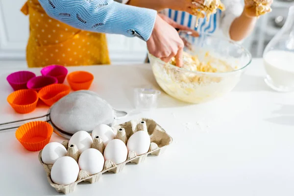 Cropped view of mother and daughter mixing dough in kitchen — Stock Photo