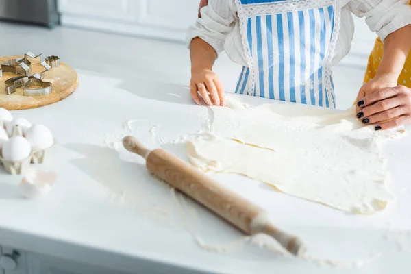 Cropped view of mother and daughter cooking and holding dough — Stock Photo