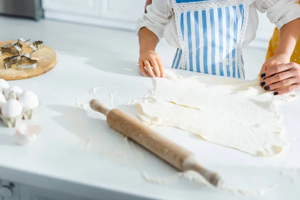 Vista recortada de madre e hija cocinando y sosteniendo la masa - foto de stock